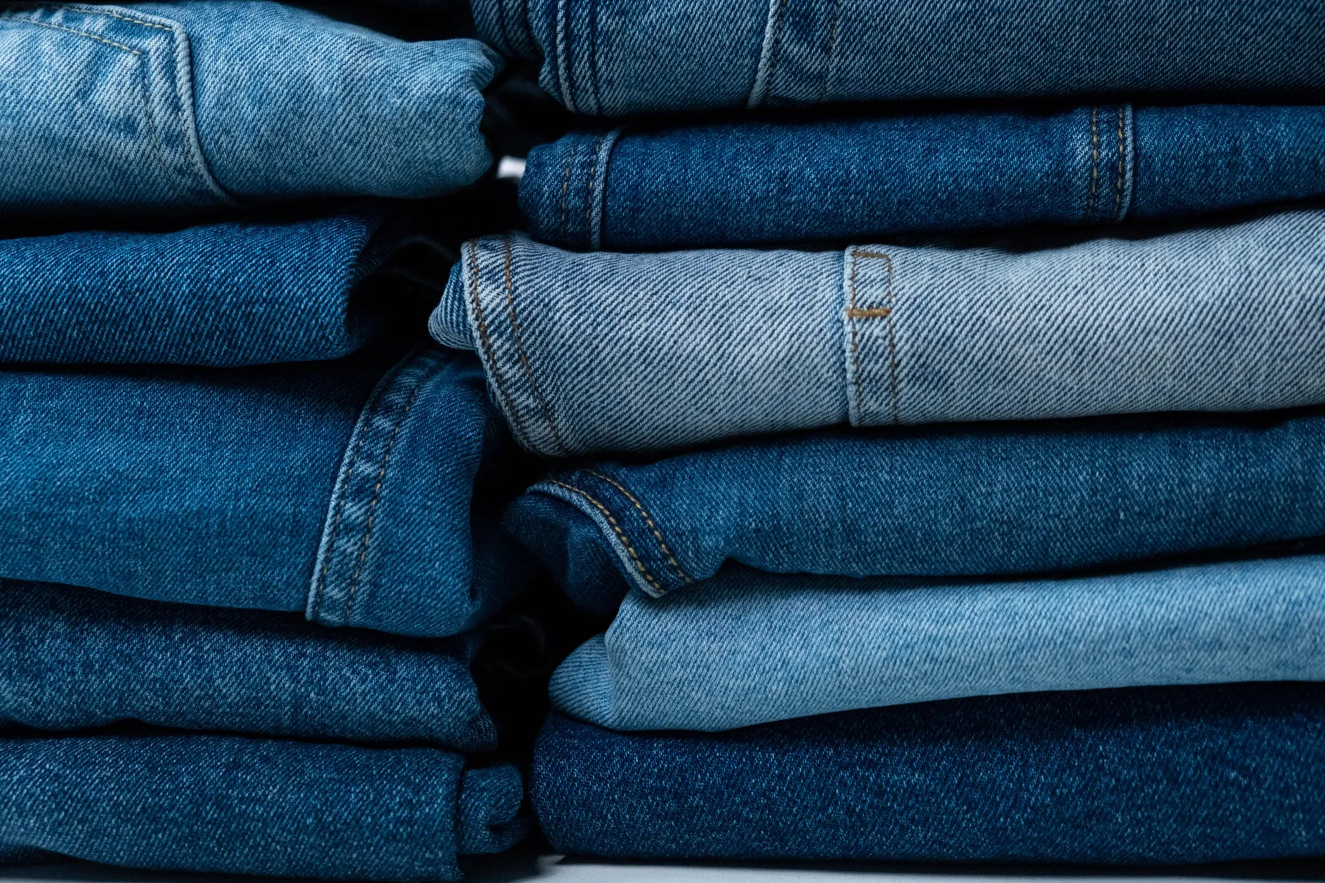 Stacks of folded jeans in indigo, mid and light washes